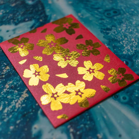 Red envelope with gold floral patterns on a blue textured background