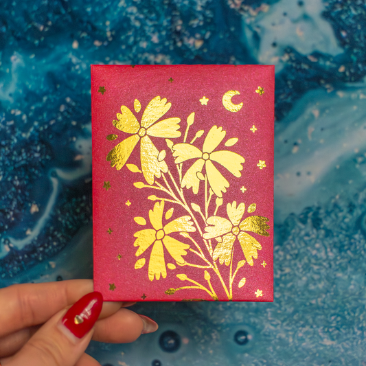 Red envelope with gold floral design held by a hand against a blue textured background